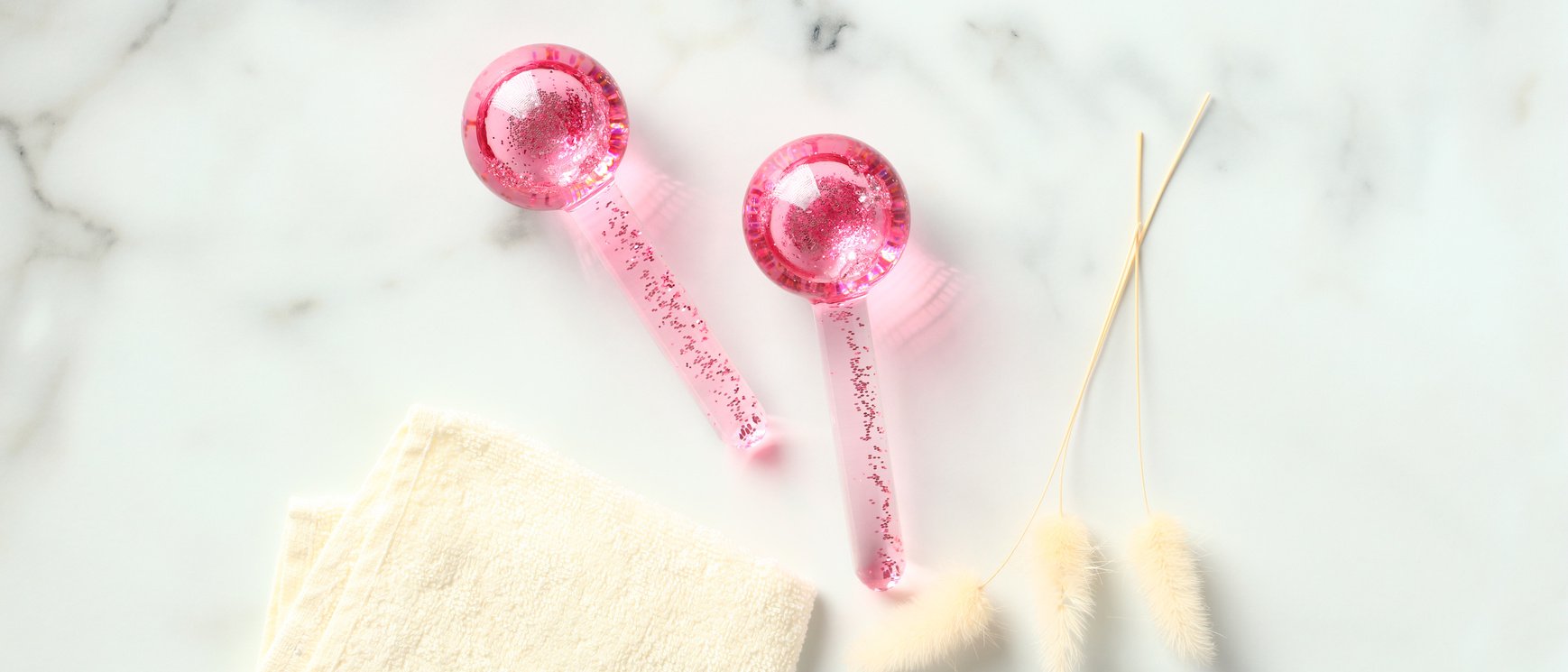 Ice Globes for Facials on Marble Table with Towel and Dried Flowers